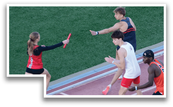 A woman wearing a red shirt and black shorts is running on a track. Description generated by AI