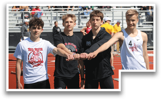 Four boys wearing black and white uniforms. Description generated by AI