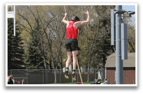 A man is jumping over a yellow and orange trampoline. Description generated by AI