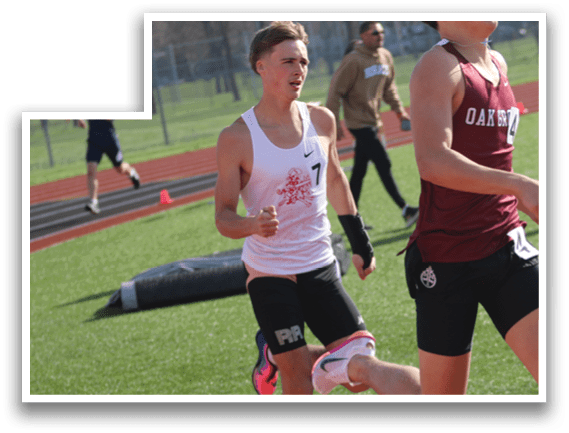 Two boys running on a track. Description generated by AI