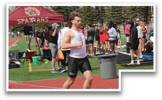 A man running on a track with a red and white shirt. Description generated by AI
