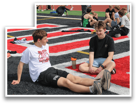 Two men sitting on the ground. Description generated by AI