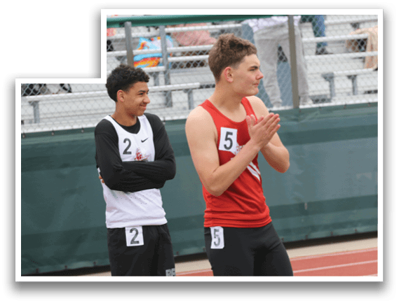 A man wearing a red shirt and black shorts is standing on a track. Description generated by AI
