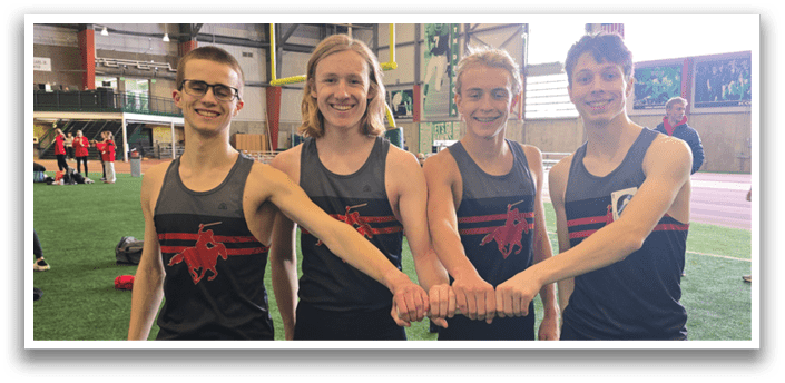Four men wearing black and red shirts and shorts pose for a picture. Description generated by AI