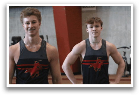 Three men wearing black and red shirts and black shorts. Description generated by AI