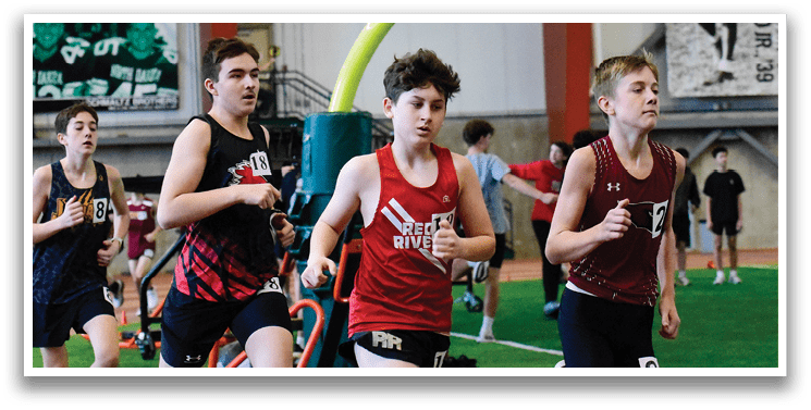 A group of young boys running on a track. Description generated by AI