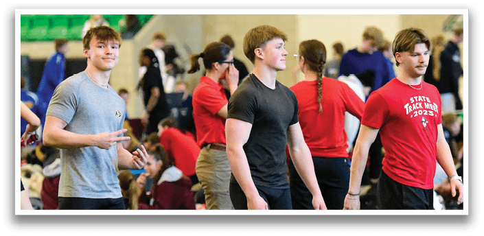 A group of men wearing black shorts and red shirts. Description generated by AI