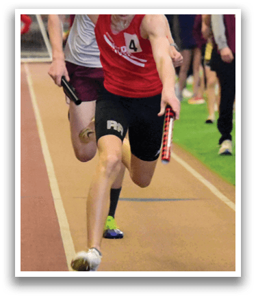 A man running on a track with a red shirt and black shorts. Description generated by AI