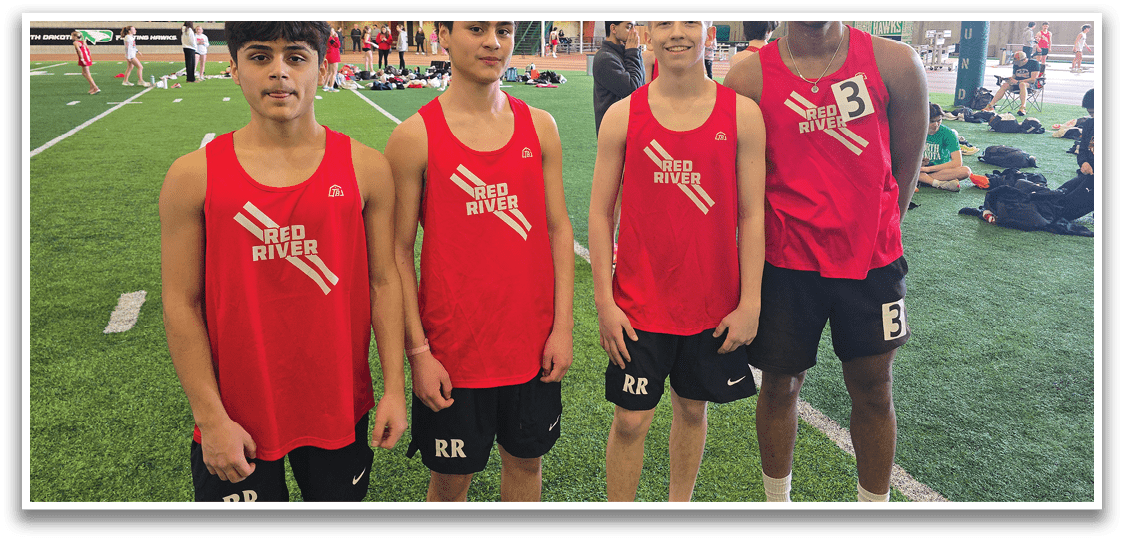Four young men wearing red shirts and black shorts. Description generated by AI
