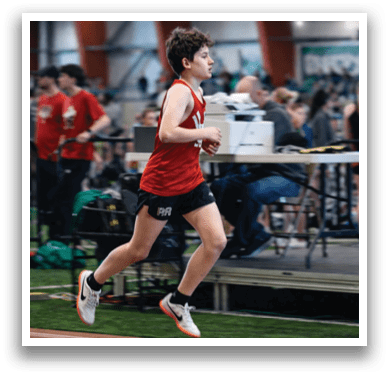 A boy running on a track. Description generated by AI
