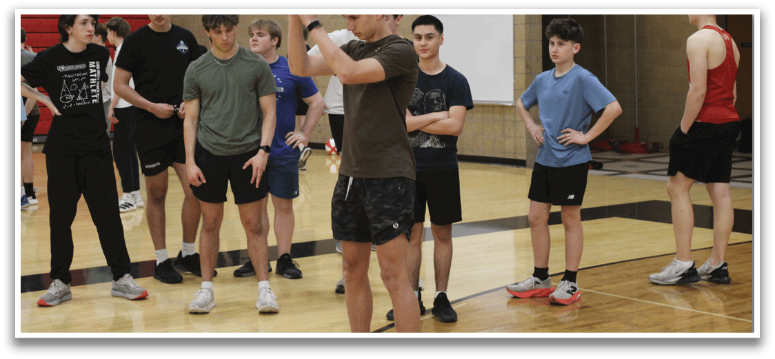 A group of people are standing in a gym. Description generated by AI