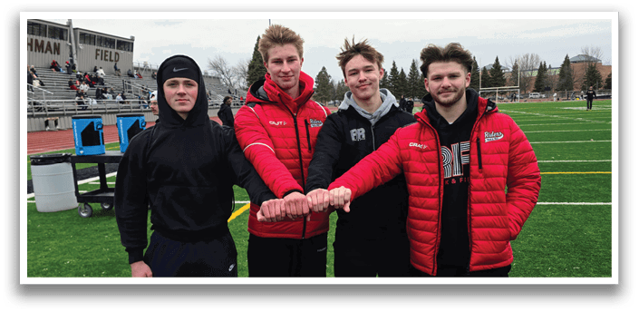 Four men wearing red and black jackets and black hats. Description generated by AI
