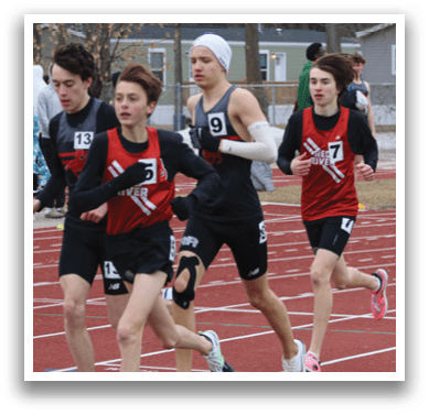 A group of young men running on a track. Description generated by AI