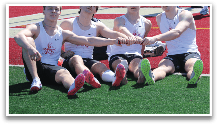 Four boys sitting on the ground with their legs crossed. Description generated by AI