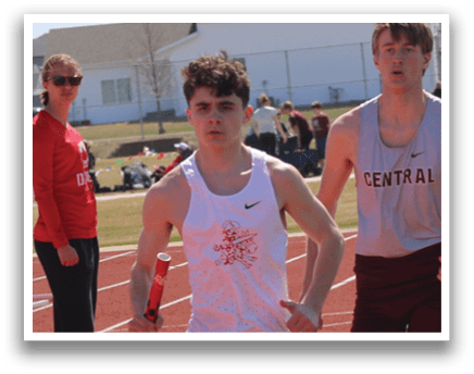 Three men running on a track. Description generated by AI