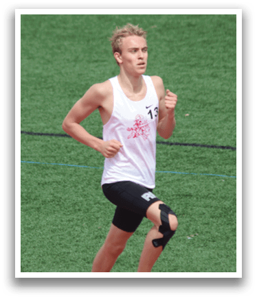A man running on a track with a white tank top and black shorts. Description generated by AI