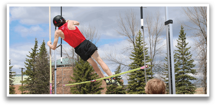 A man is jumping in the air on a pole. Description generated by AI