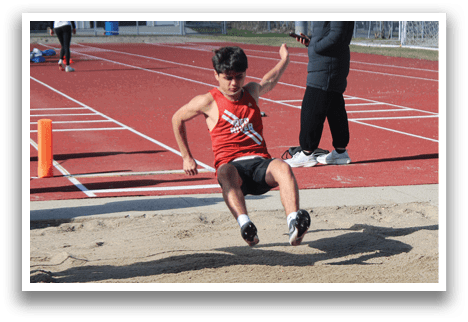 A man is jumping in the air on a track. Description generated by AI