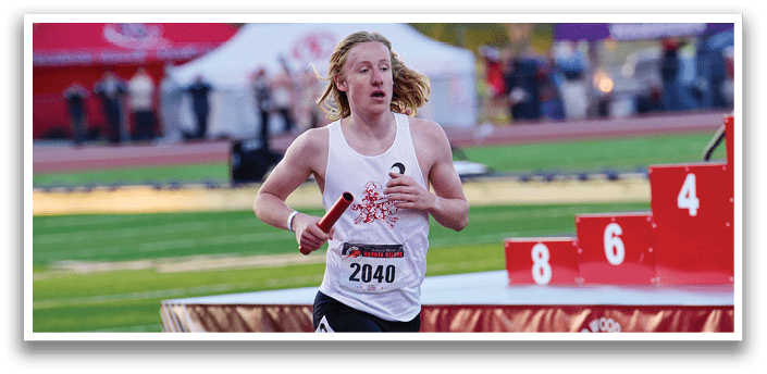 A runner is running on a track with a red sign in front of him. Description generated by AI