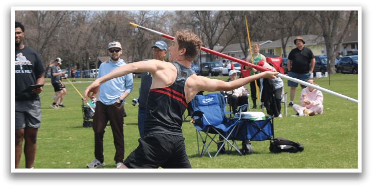 A man in a black shirt and red shorts is throwing a javelin. Description generated by AI