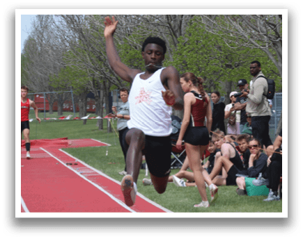A man is jumping in the air on a track. Description generated by AI