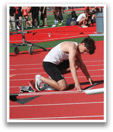 A man is bending over to pick up a white object on a red track. Description generated by AI
