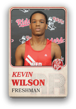 A person wearing a red athletic tank top with the word “RED" stands in front of a backdrop featuring the text "Riders" and "RRHS" with a mascot logo, and the card below identifies the person as Kevin Wilson, a freshman. Description generated by AI