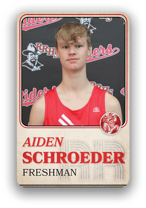 A person wearing a red sports jersey is shown on a card with the name Aiden Schroeder and the label Freshman against a background featuring the text Riders and RRHS. Description generated by AI