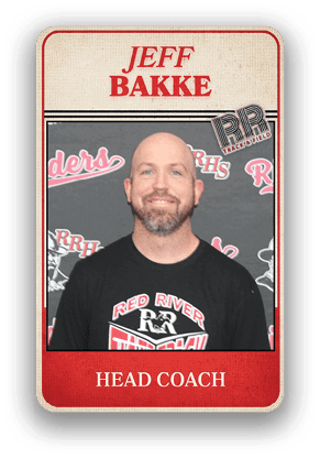 An adult wearing a black Red River Track and Field shirt stands in front of a backdrop with Red River Raiders logos with the text Jeff Bakke Head Coach above. Description generated by AI