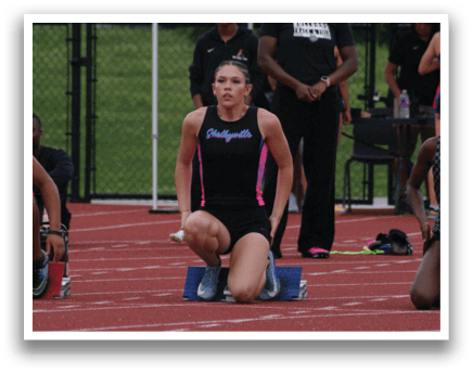 A woman is running on a track, wearing a black and white outfit. Contenido generado con IA