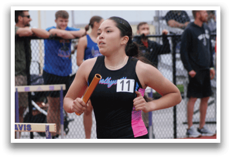 A woman is standing on a track with her hands on her hips. Contenido generado con IA