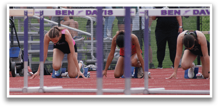 A group of female runners are lined up on a track, preparing to run. Contenido generado con IA