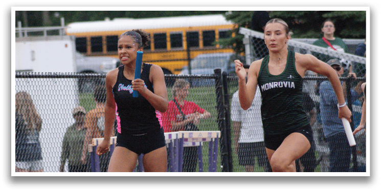 Three female runners wearing sports bras and shorts are running on a track. Contenido generado con IA