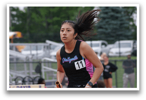 A woman wearing a black and white shirt is running on a track. Contenido generado con IA