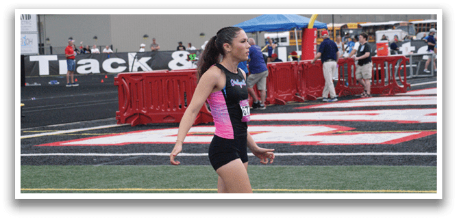 Two female athletes are running on a track, one of them jumping over a hurdle. Contenido generado con IA