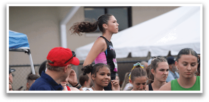 A group of female athletes wearing uniforms and standing on a track. Contenido generado con IA
