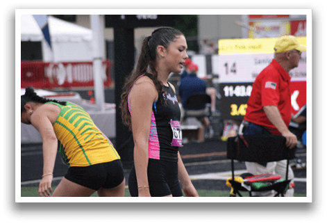 A woman wearing a black and white shirt is running on a track. Contenido generado con IA