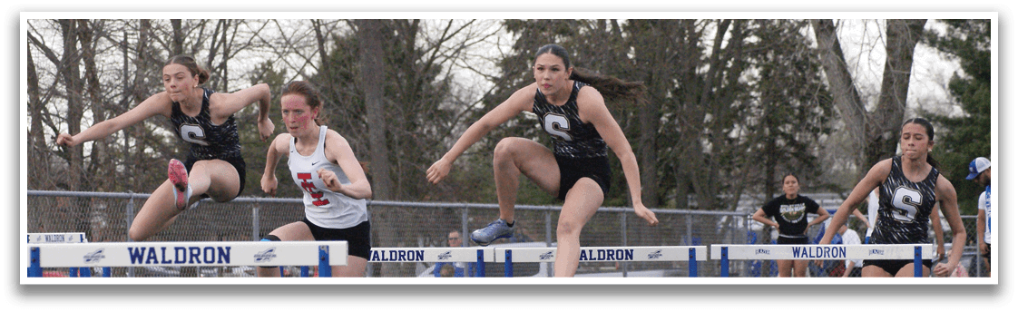 A group of girls are jumping over a hurdle on a track. Contenido generado con IA