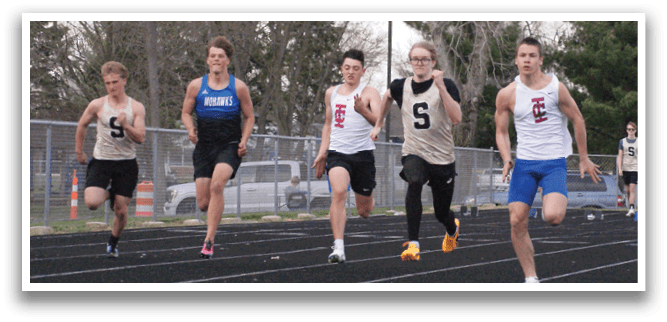 A group of young men running on a track, some wearing blue shorts. Contenido generado con IA