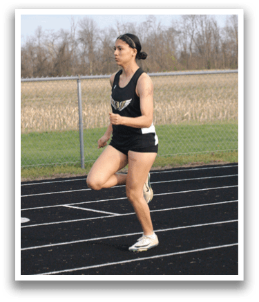 A woman is running on a track, wearing a black and white outfit. Contenido generado con IA