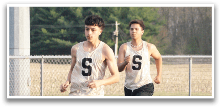 Two men are running on a track, one wearing a number 5 shirt. Contenido generado con IA