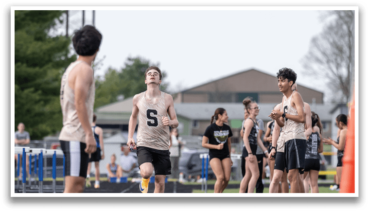 A group of people are running on a track, with one man wearing a black and white shirt. Contenido generado con IA