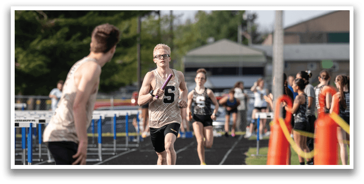 A boy and a girl are running on a track, with the boy in front of the girl. Contenido generado con IA