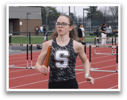 A female athlete wearing a black and white uniform is running on a track. Contenido generado con IA
