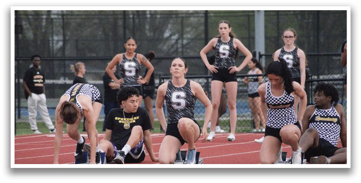 A group of female athletes are lined up on a track, getting ready to compete. Contenido generado con IA