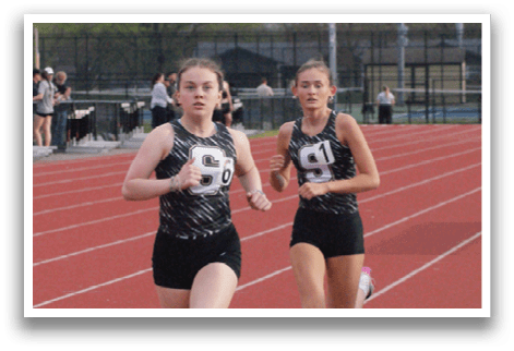 Two female runners are racing on a track, one ahead of the other. Contenido generado con IA