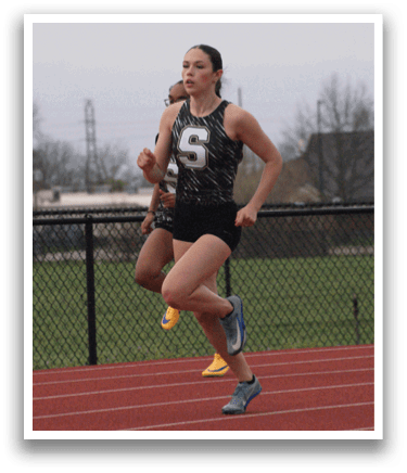 Two female runners are racing on a track, one wearing a black and white outfit and the other wearing a black and white checkered outfit. Contenido generado con IA