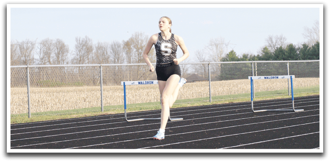 A woman is running on a track, wearing a black and white shirt. Contenido generado con IA