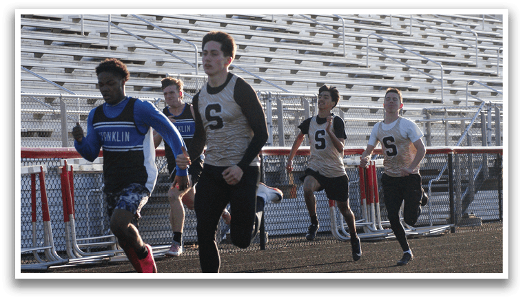 A group of young men are running on a track, with one of them wearing a blue and black uniform. Contenido generado con IA