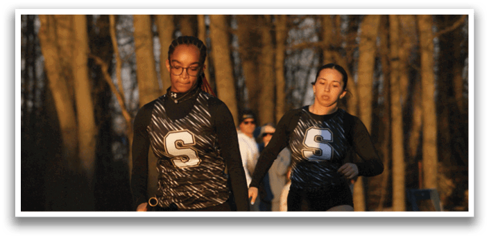 Three people are running on a track, with one person in the lead. Contenido generado con IA
